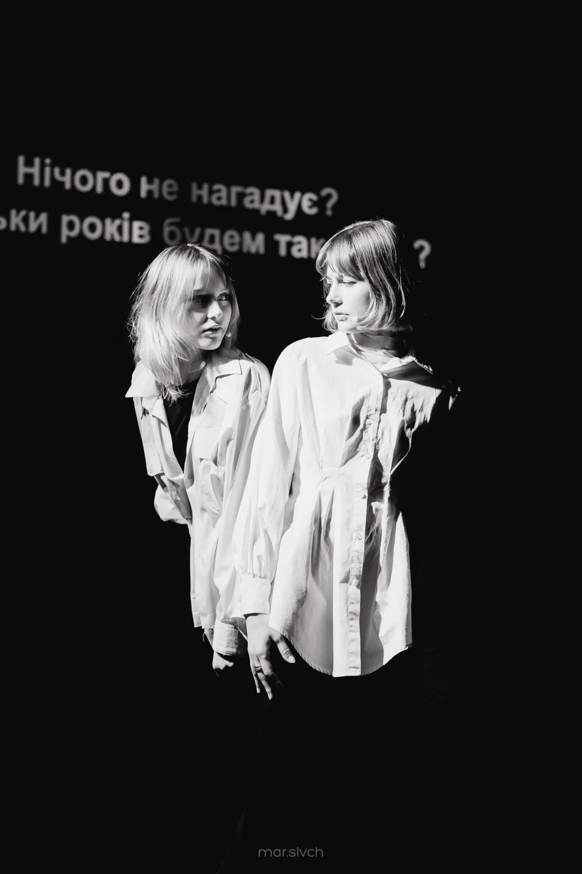 Two performers stand before a projection of Ukrainian text during Vorspiel.