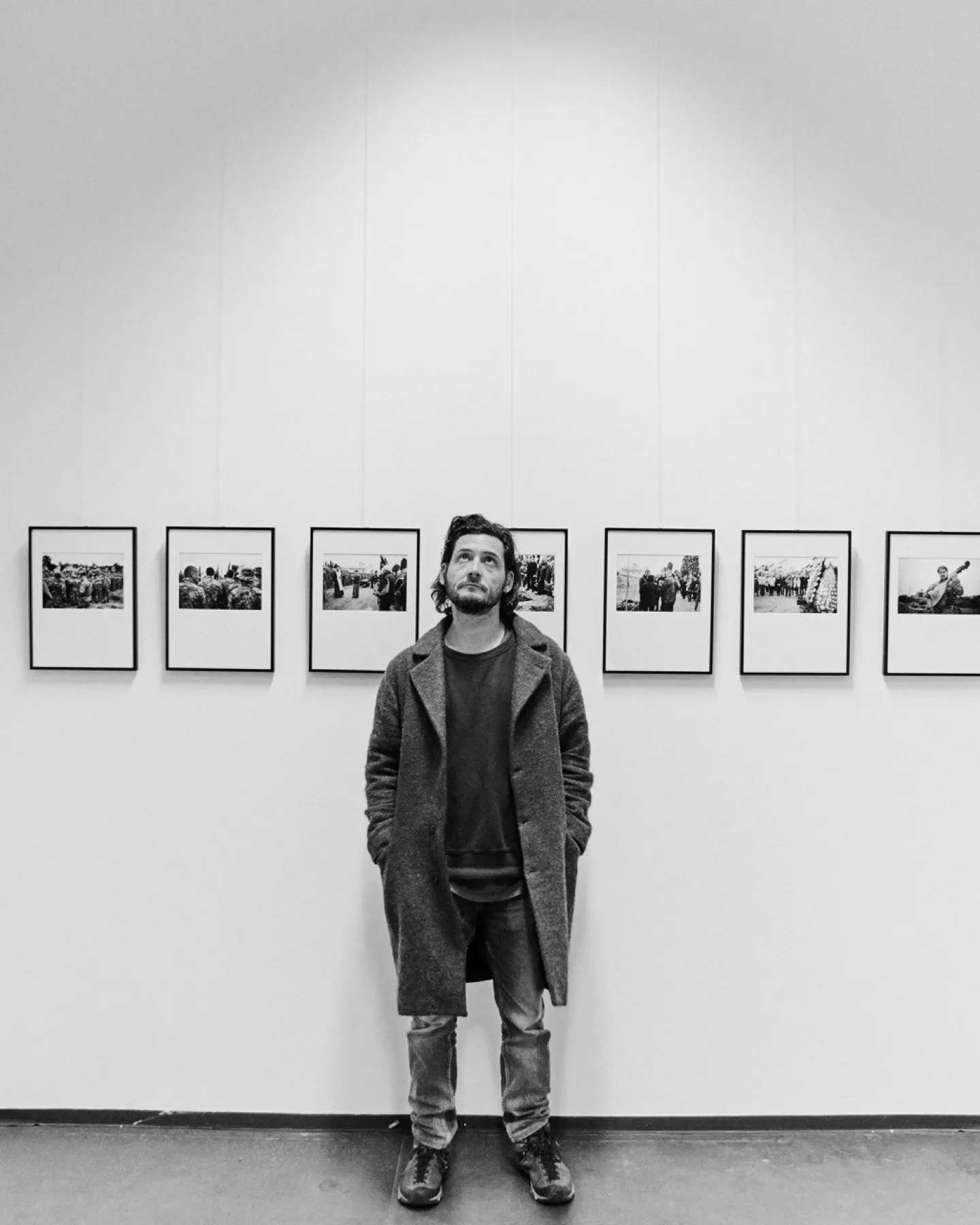 A visitor stands before a row of black-and-white photographs at the Im Alltag exhibition.